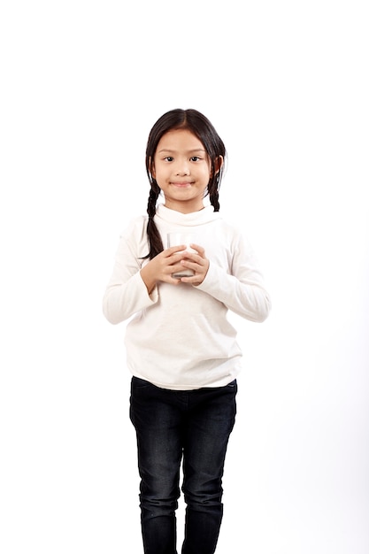 Preschool girl holding a glass with milk 