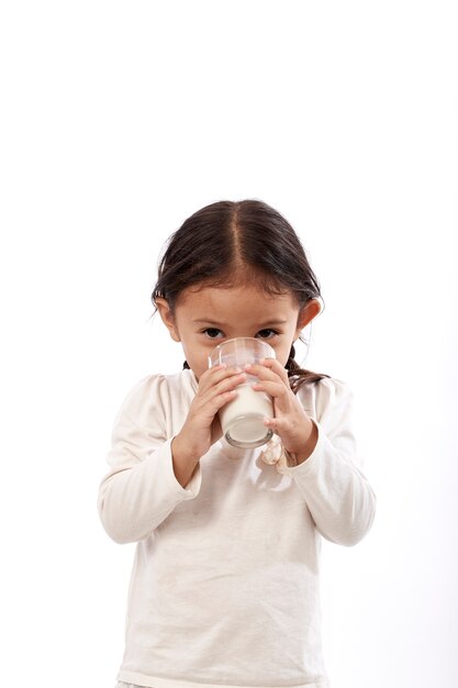 Preschool girl holding a glass with milk 