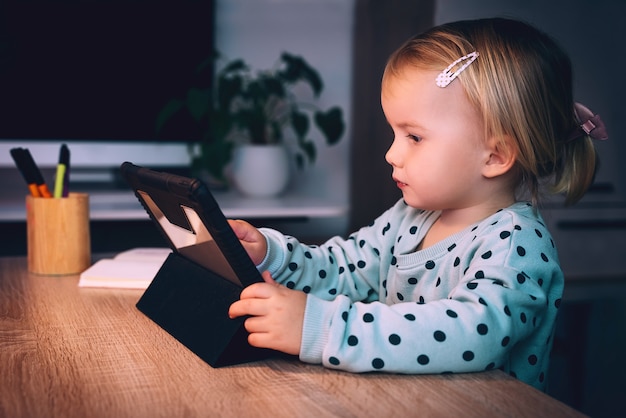 Photo preschool girl with tablet pc at home child using digital technology and internet communication