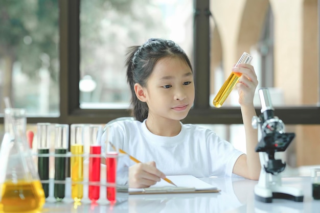 Preschool meisje is geïnteresseerd in laboratoriumlessen om aantekeningen te maken op boeken voor haar studie