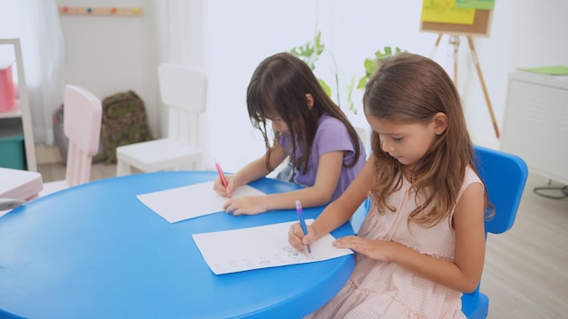 Insegnante di scuola materna con i bambini studiano in classe. l'asilo torna a scuola