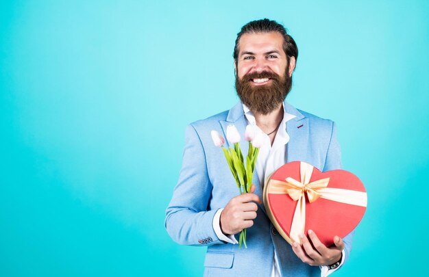 Present box for her celebrate the holiday man with beautiful spring flowers Fresh tulips bouquet man holding bouquet of tulips happy valentines day man share tulip flowers