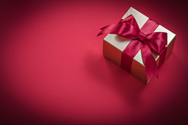 Подарочная коробка на красном фоне праздников концепции