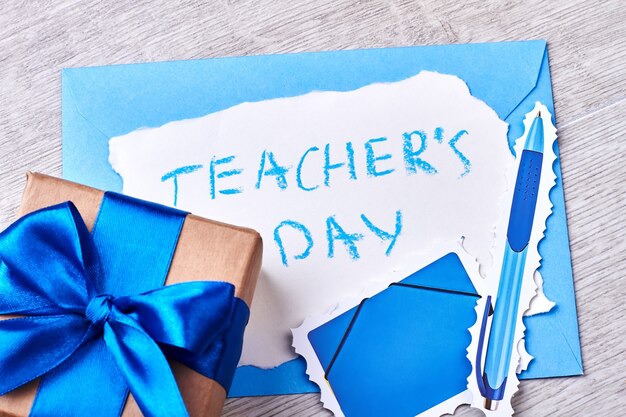 Present box with blue bow. Teacher's Day congratulation and gift.