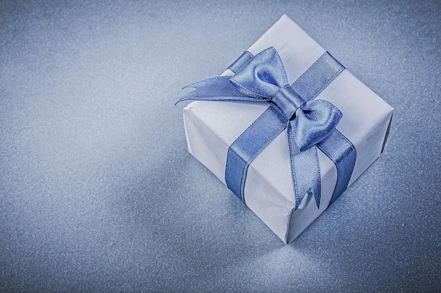 Present box with bow on blue background