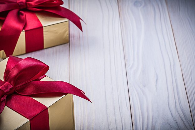 Present boxes with satin ribbons on wood board copy space holidays concept