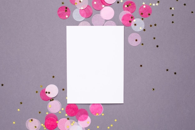 Carta regalo e coriandoli rosa con stelle dorate su grigio