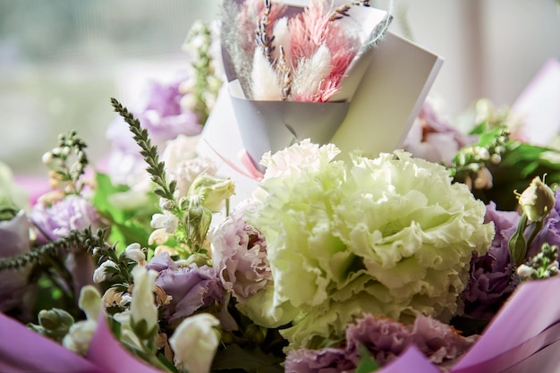 Present post card close up with delicate big flowers bouquet of eustoma and dry flowers under day light with dry colorful Lagurus ovatus grass Flowers delivery and present concept High quality photo