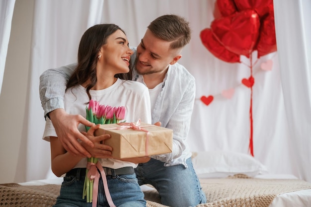 Present for woman Festive decoration Young couple are together at home