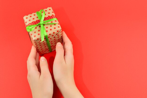 Present in woman hand on red background