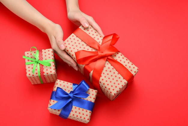 Present in woman hand on red background.