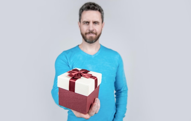 Present for womens day giftbox in hand of successful handsome man selective focus bearded man with business reward occasion greeting businessman showing gift box corporate present