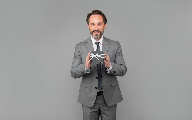 present for womens day senior ceo hold corporate giftbox grizzled man prepare for love date happy man with business reward occasion greeting businessman show heart gift box valentines day