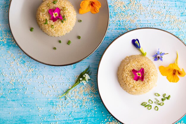 Presentatie van een quinoa bord versierd met eetbare bloemen