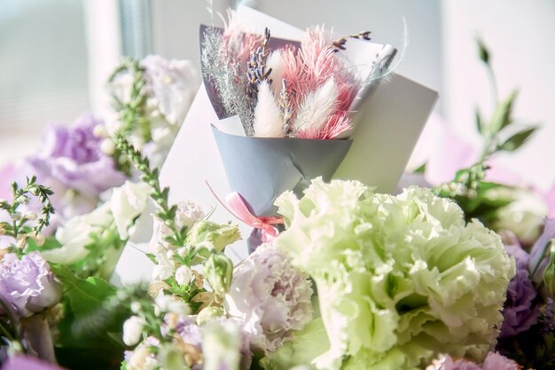 Presenteer een ansichtkaart close-up met een delicaat groot bloemenboeket van Eustoma en droge bloemen