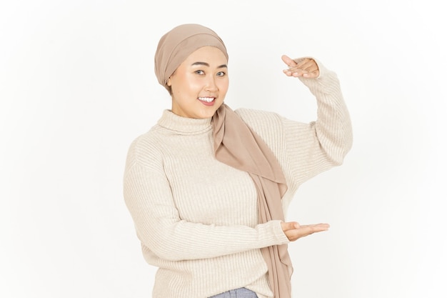 Presenting and Holding Big Product of Beautiful Asian Woman Wearing Hijab Isolated On White