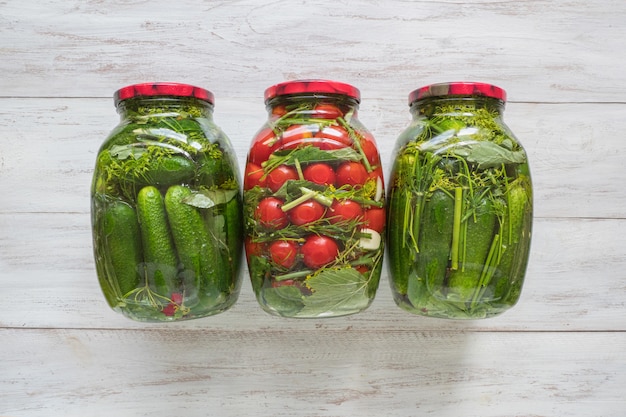 Preservation of tomatoes and cucumbers. Jars of pickles and tomatoes for the winter.