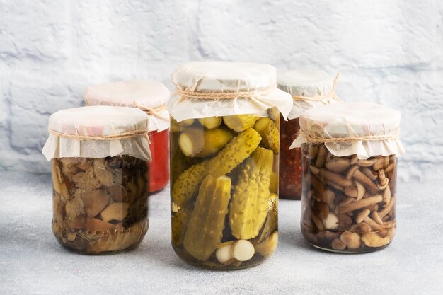 Foto conservazione delle verdure nelle banche. prodotti di fermentazione. raccolta di cetrioli e funghi per l'inverno. copia spazio.