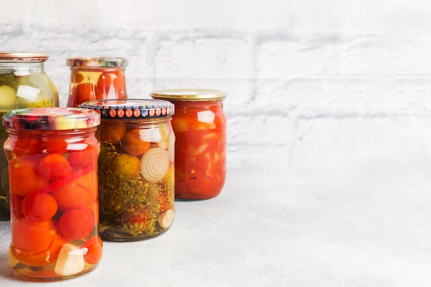 Foto conservazione delle verdure nelle banche. prodotti di fermentazione. raccolta di cetrioli e pomodori per l'inverno. copia spazio