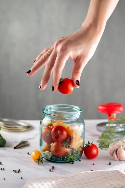 preservation of vegetables, the process of cooking, a woman's hand puts food in a jar