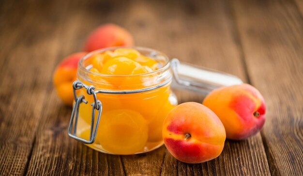 Preserved apricots on wooden background selective focus