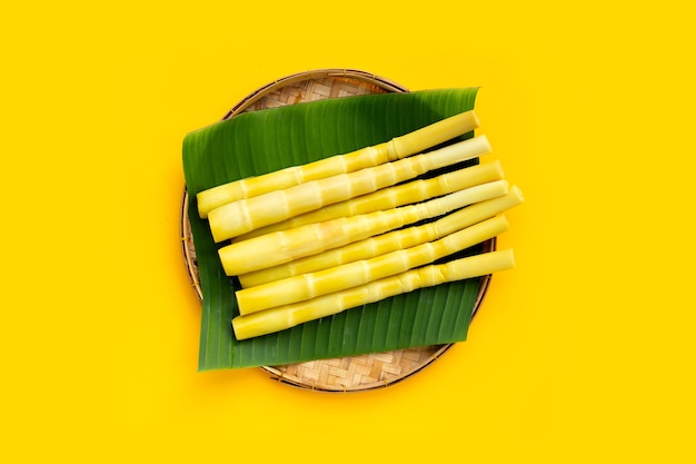 Preserved bamboo shoot in bamboo basket on yellow background.