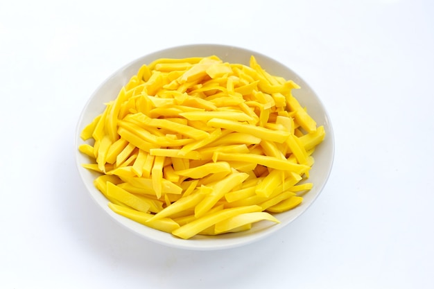 Preserved bamboo shoot in white bowl on white background.