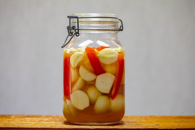 Photo preserved onion and red pepper in vinegar in traditional glass