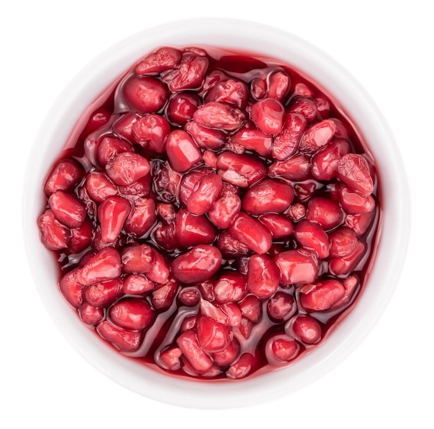 Photo preserved pomegranate seeds isolated on white background selective focus closeup shot