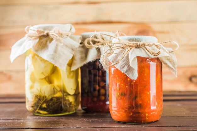 Preserved vegetables on wooden background