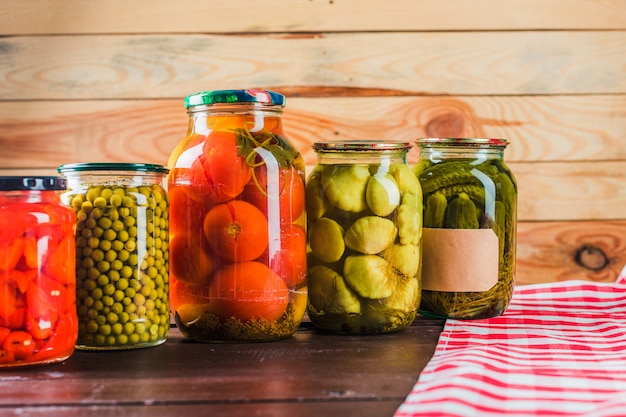 Preserved vegetables on wooden background