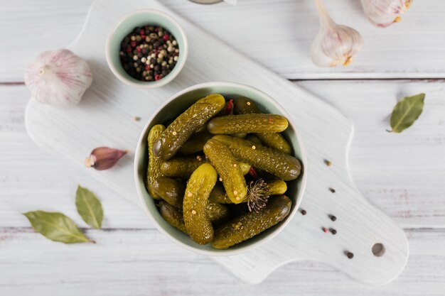 Preserving pickled cucumbers, seasonings and garlic on a white wooden table