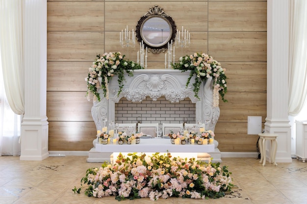 Presidium for the newlyweds decorated with candles and vases with white and pink natural flowers