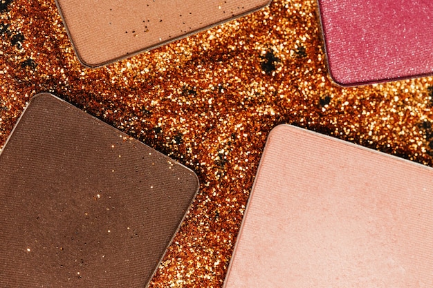 Pressed eyeshadows lie on golden glitter