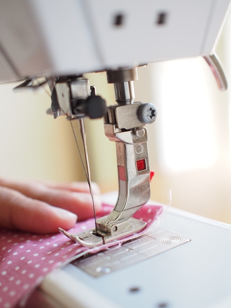 Presser foot of sewing machine threading the textile 