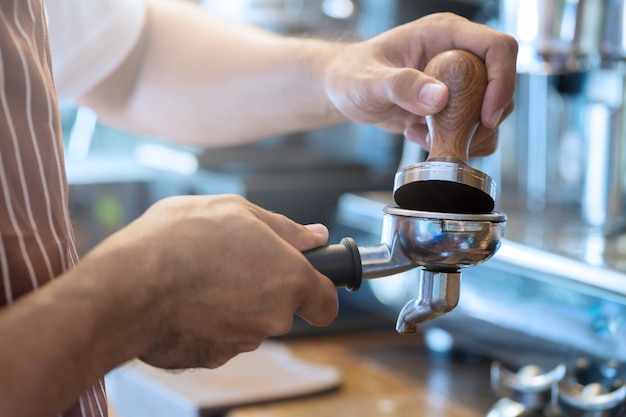 Pressing coffee with tamper before brew Selective focus