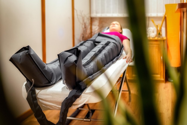 Pressotherapy procedure with overalls in a beauty salon Modern lymphatic drainage massage Health and beauty concept