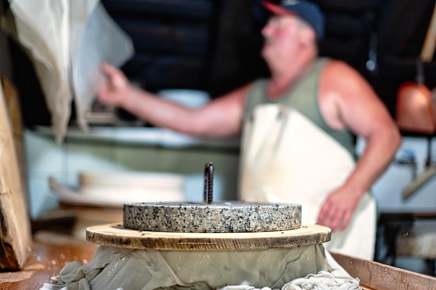 La pressione per creare la forma di formaggio tipica delle montagne bergamasche nel nord italia