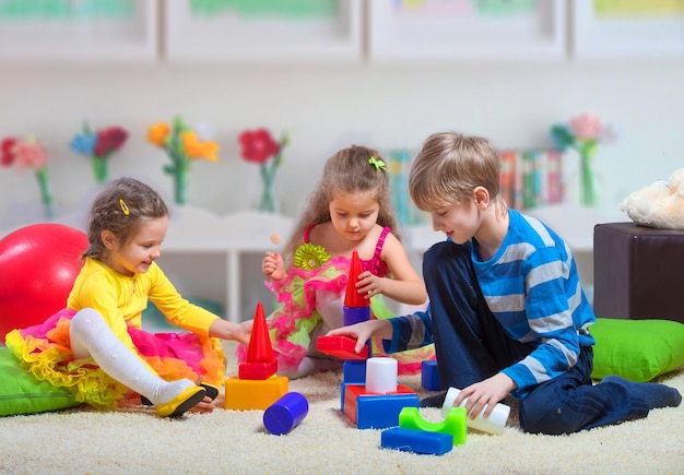 Preteen boy playing with two younger girls