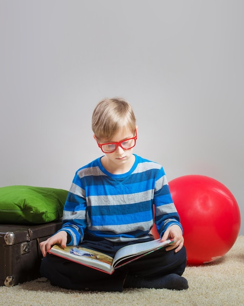 Preteen boy sitting on floor and reading book