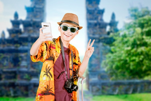 Preteen boy taking a selfie near the Handara gate