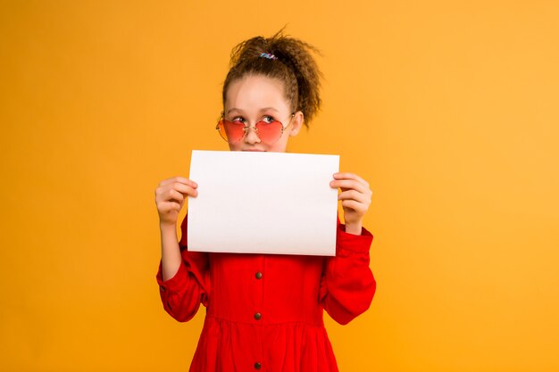 Preteen girl holding blank white paper