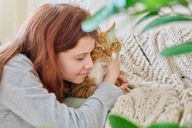 Preteen girl hugging cat with love face close up Home pet old ginger cat with young owner together Animals love friendship children lifestyle concept