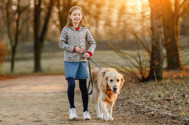 Preteen girl with golden retriever dog