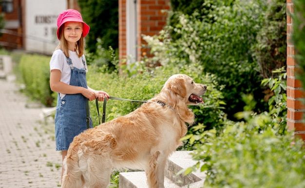 Preteen girl with golden retriever dog