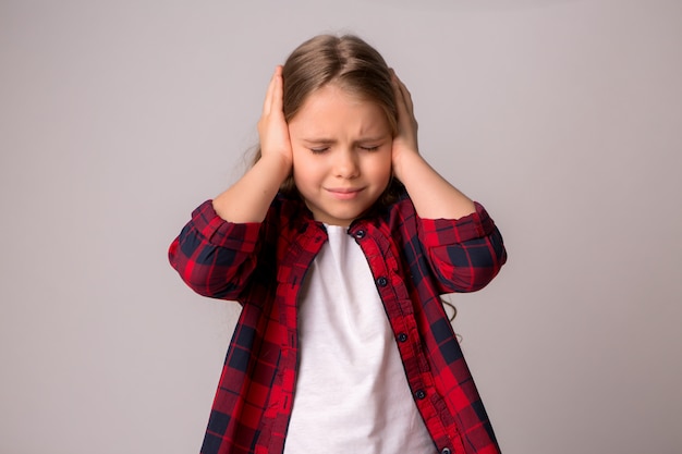 preteen girl with her hands covering her ears