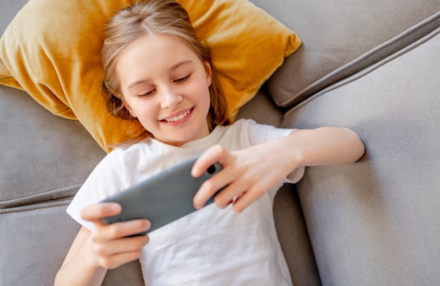 Preteen girl with smartphone at home