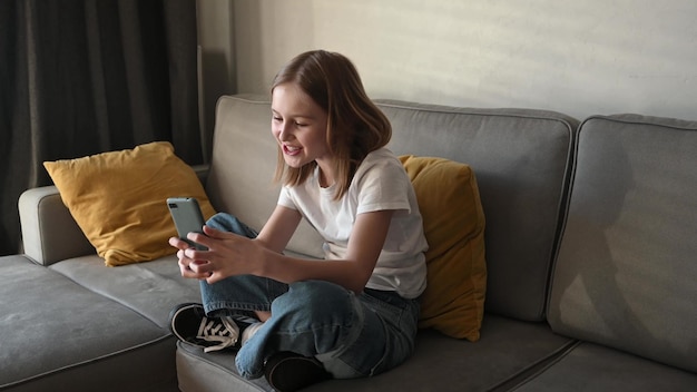 Preteen girl with smartphone at home