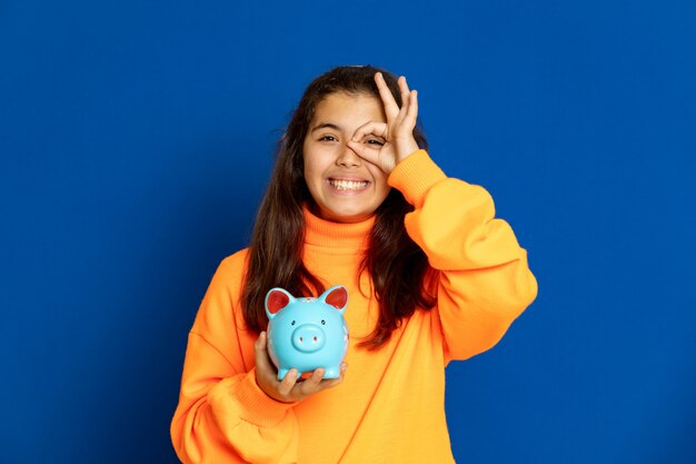 Preteen girl with yellow jersey gesturing over blue wall