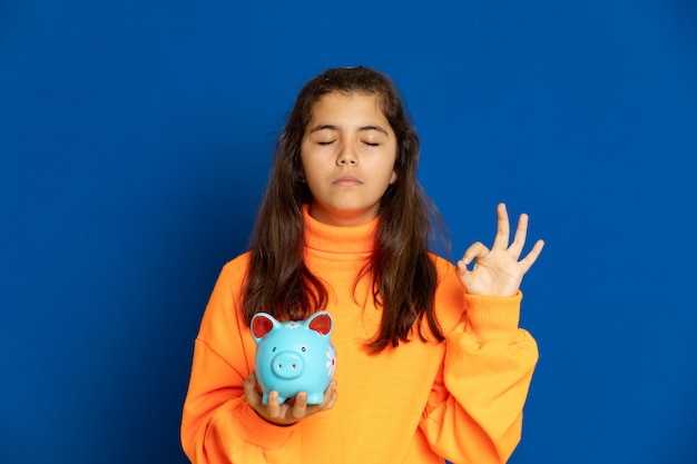 Preteen girl with yellow jersey gesturing over blue wall